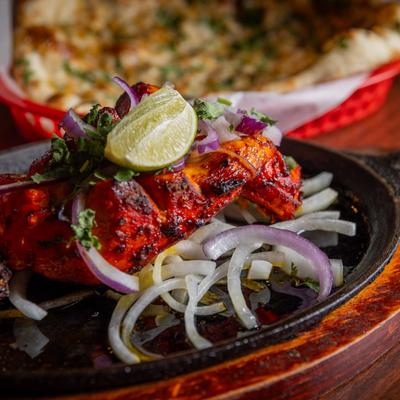 Grilled chicken leg, marinated in Tandoori Masala, with cilantro, onions, and lime.
