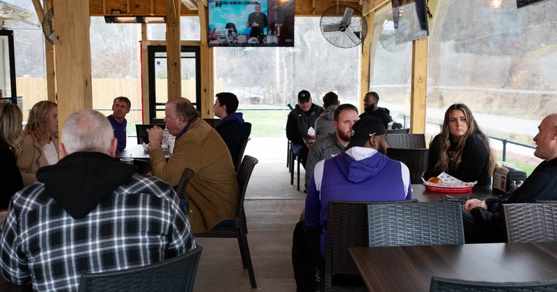 Wide view to terrace with people and tv screen above