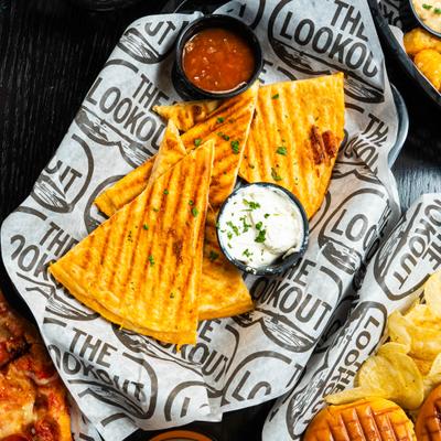 Chicken quesadilla served with salsa and sour cream.