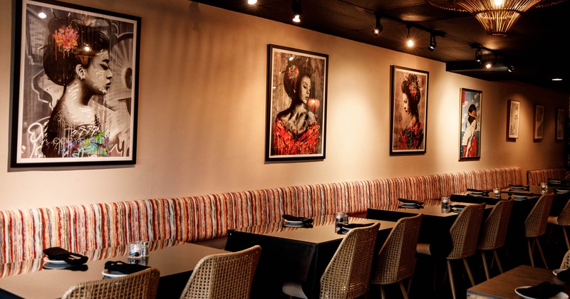 Interior dining area with striped seating, black tables and woven chairs