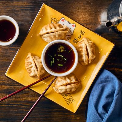 Pot stickers with a soy sauce for dipping.
