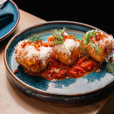 House Cultured Tzatziki served in a rich tomato sauce, topped with grated cheese.