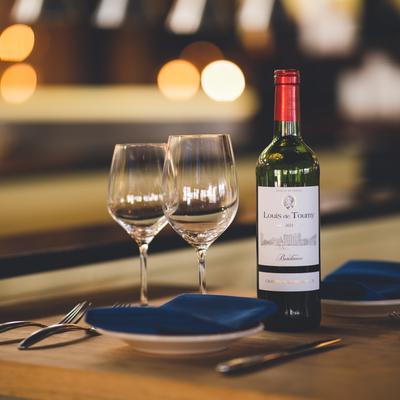 Interior, Table set with tableware, glasses, and a bottle of wine.