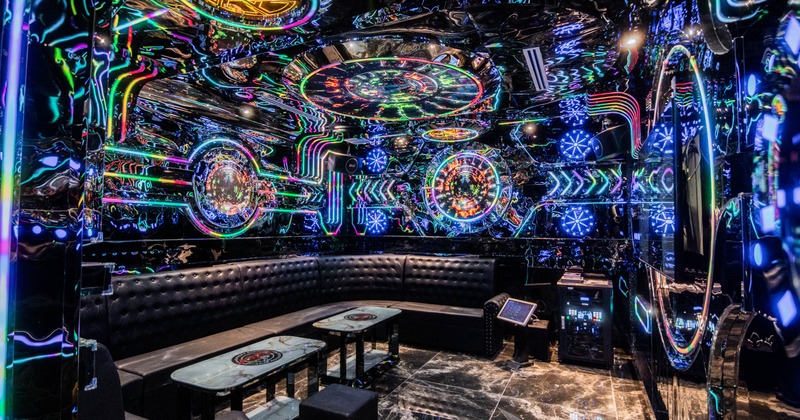 Interior, karaoke room, neon lighting in various colors, sofa with coffee tables