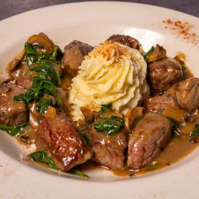 Beef tips entrée served with mashed potatoes and mushrooms.
