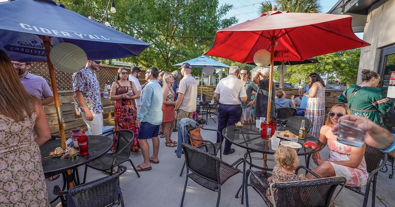 Guests engaged  in conversation, enjoying drinks and food in the patio