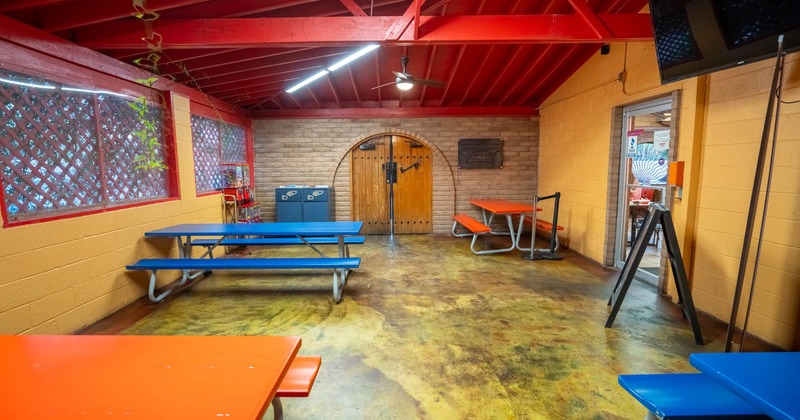 A room with picnic tables and benches
