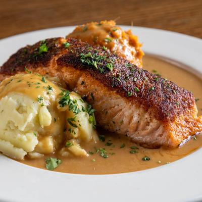 Bourbon Salmon served alongside mashed potatoes and sweet potato mash.
