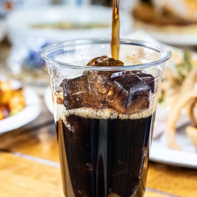 Iced soda being poured into a cup.