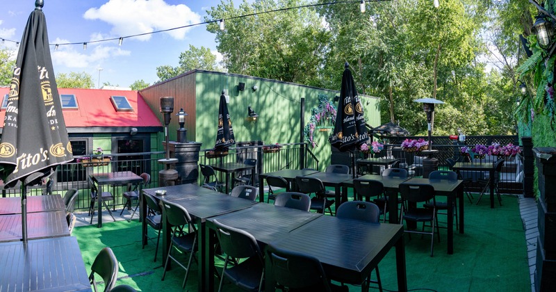 Exterior, seating area, tables and chairs with black parasols, metal railing