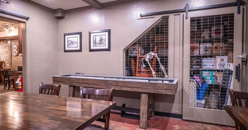 Interior, area with tables, chairs  and a shuffleboard table