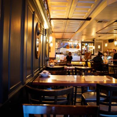 Interior with wood paneling and a mixture of wooden chairs and tables.