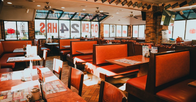 Dining area, booths on the left side and tables with chairs on the right