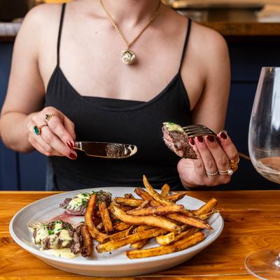 A person eating the steak frites.
