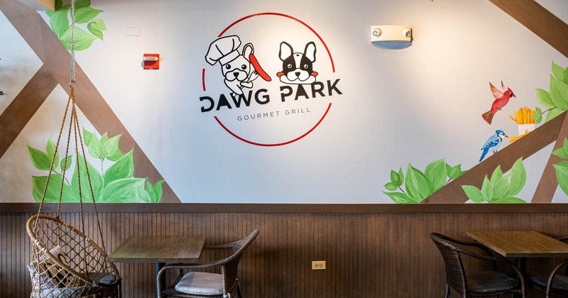 Interior, seating area by a wall with the Dawg Park logo