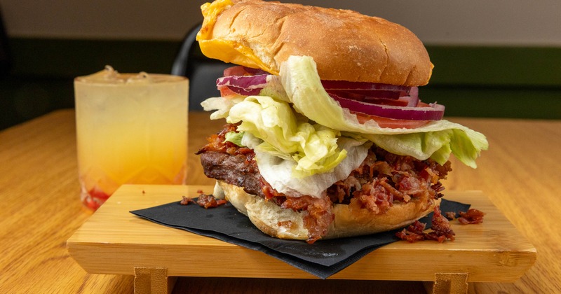 Bacon Cheeseburger topped with lettuce, tomato and onion