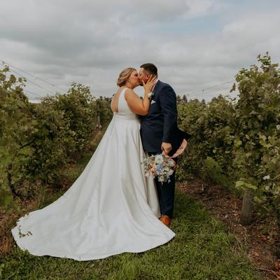 Wedding couple standing in the vines at Next Chapter Winery.