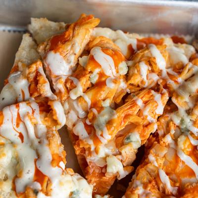 Flatbread topped with buffalo chicken, hot sauce, mozzarella, blue cheese, and ranch.