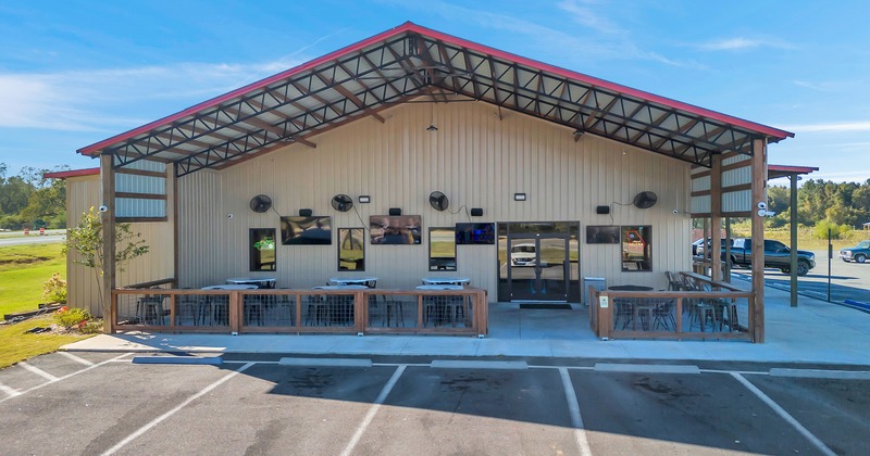 Exterior, front view to restaurant, tables and vhairs in fron t the entrance, part of parking lot