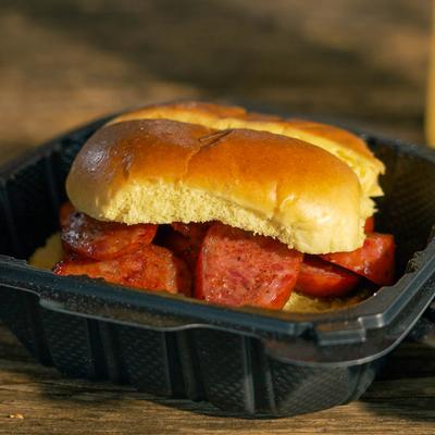 Barbecue sausage sandwich in a takeout container.