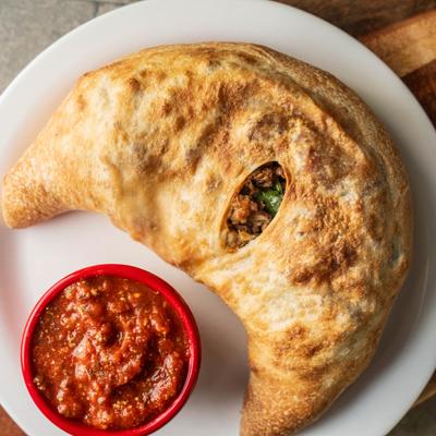 Stuffed Poppy Calzone with dip, plated.