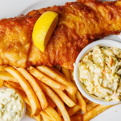 Fish and chips served with coleslaw, french fries, and tartare sauce.
