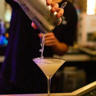 Bartender pouring a Martini cocktail.