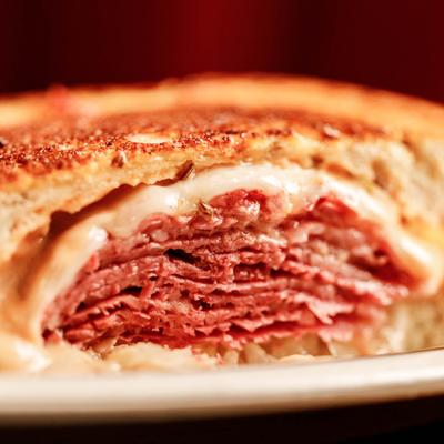 Close up view of a Reuben sandwich on a plate.