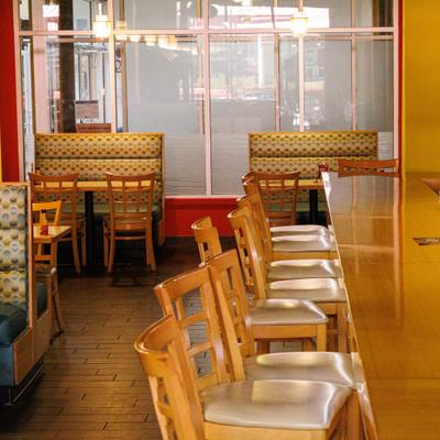 Restaurant interior with counter and booth seating.