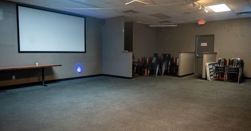 Interior, convention and presentation room, large projector screen, grey walls and carpeting