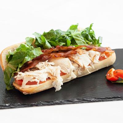Sandwich with turkey, bacon, lettuce, and tomato.