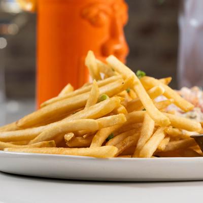 Plate of fries with tikki mug in the background.