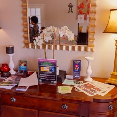Vanity area with mirror, lamps and various items.