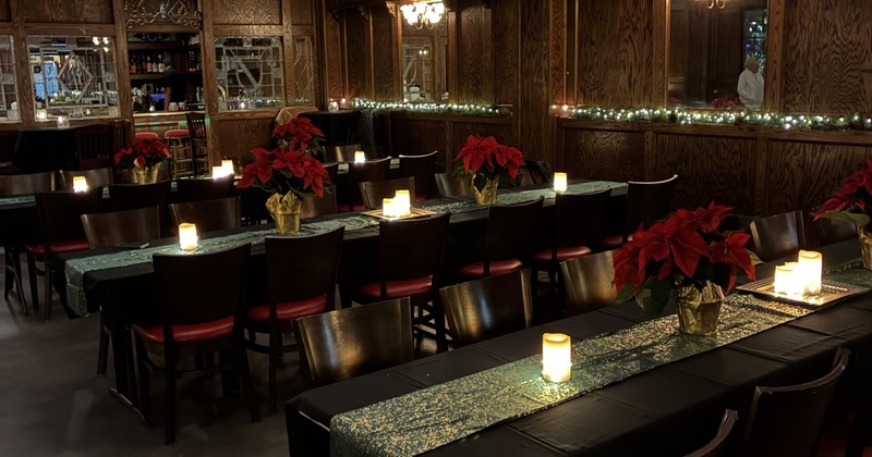 Dining area with decorated tables and candles, and mirrored walls with festive lights