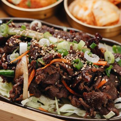 Beef Bulgogi on a bed of shreded babbage, garnished with sesame seeds and green onions.