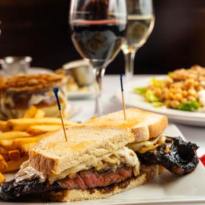 Steak sandwich served with fries and wine