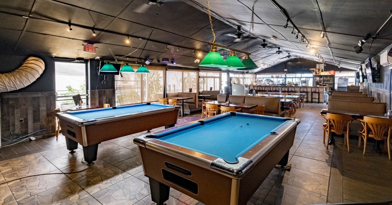 Interior of a bar with pool tables, booths, and a bar area