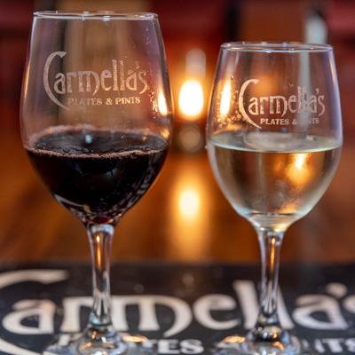 Red and White wine glass on a table with warm light in the background, side view