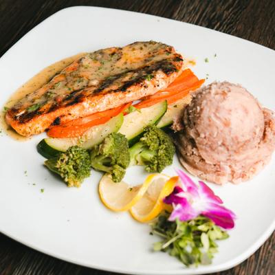 Grilled salmon fillet served with a side mashed beans and vegetables.