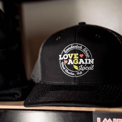 Love Again Local merchandise caps.