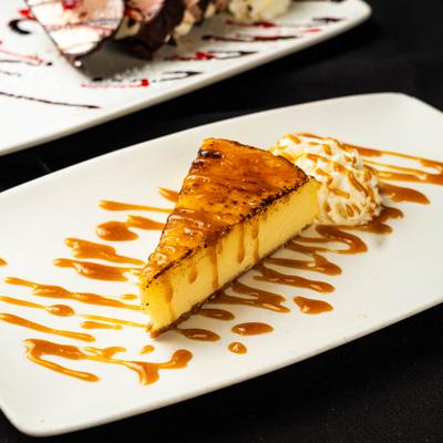 Cheesecake slice drizzled with caramel sauce.