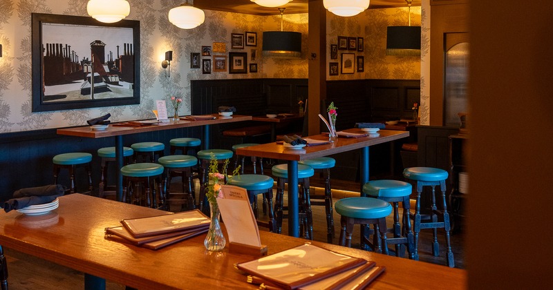 Bar area, bar tables, stools, bartender, guest