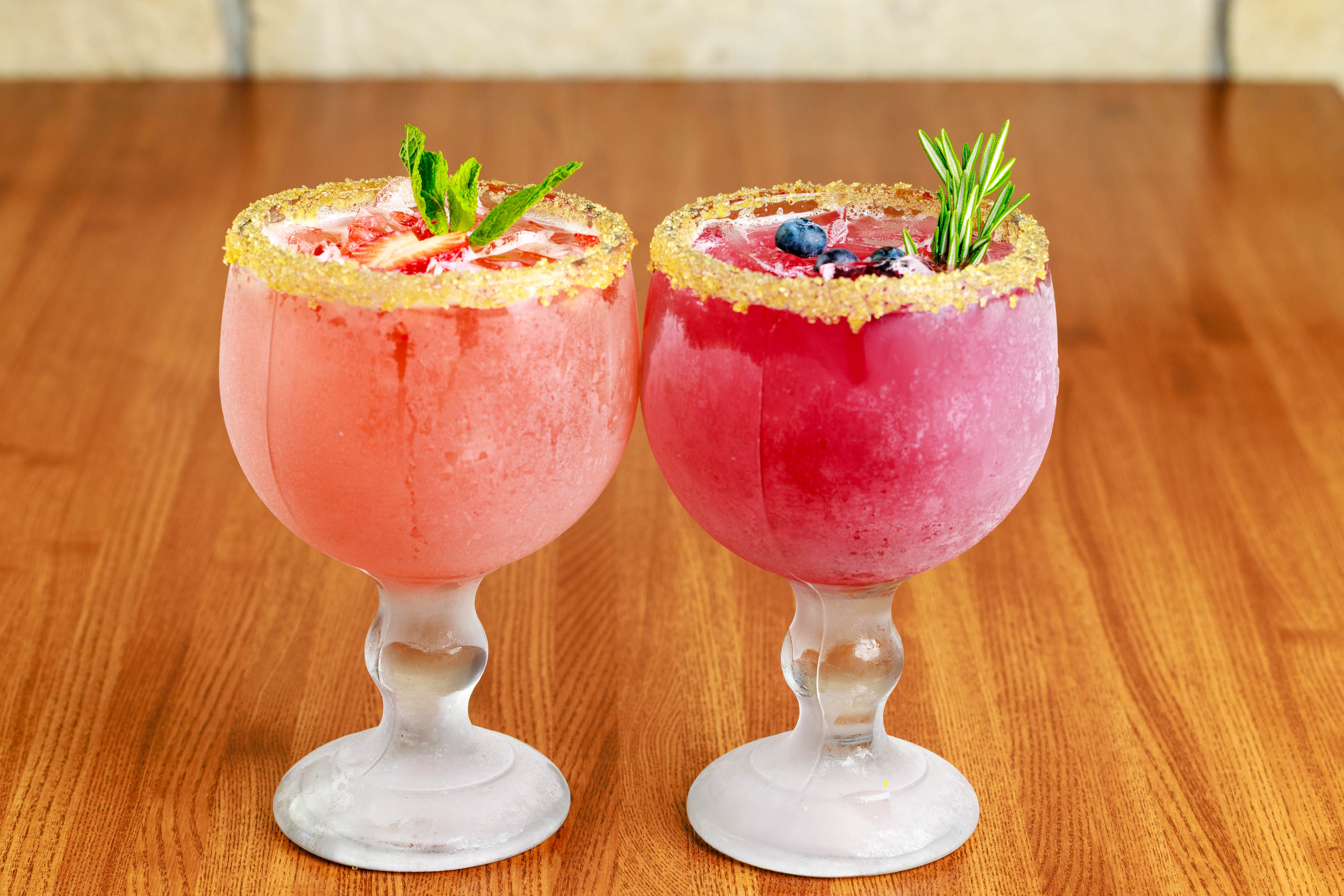 Skinny strawberry margarita and blueberry margarita on a wooden table