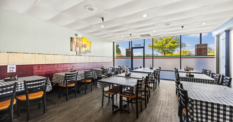Insid, tables covered in black and white checkered tablecloths and large windows