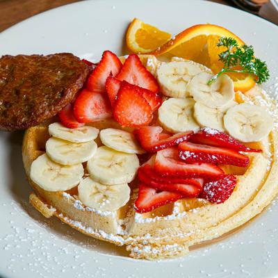 Strawberry Banana waffle with a sausage patty on the side.