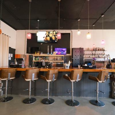 Bar area featuring a counter with several bar stools and hanging lights.