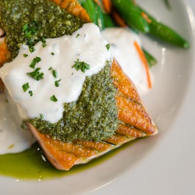Pan-seared salmon with pesto and creamy white sauce.