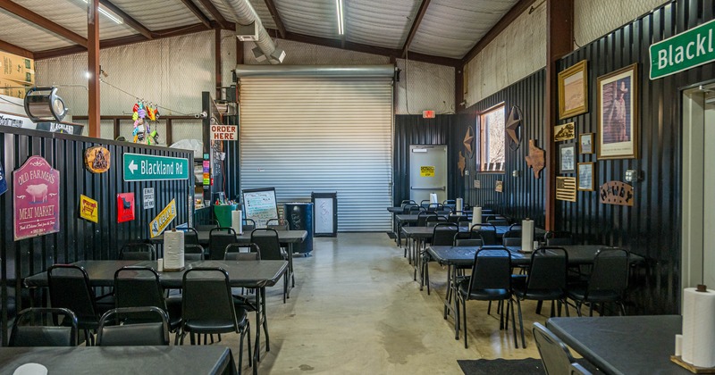 Interior, open space dining area, tables and chairs ready for guests, concrete flooring