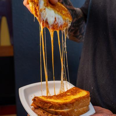 Grilled cheese sandwich with melted cheese stretching.