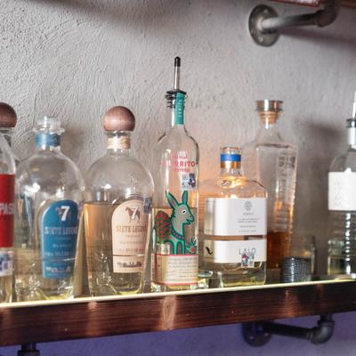 Assorted mezcal and tequila bottles on a shelf.